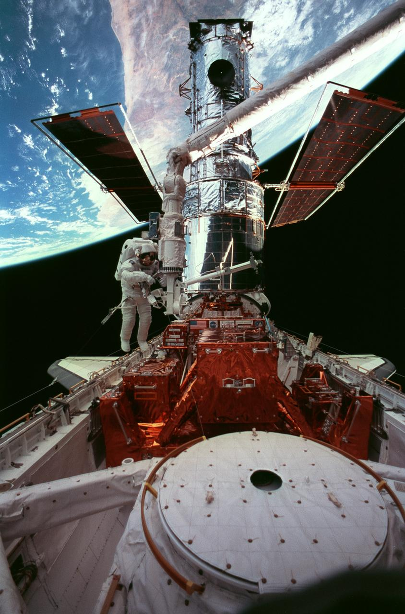 El telescopio espacial Hubble recibiendo mantenimiento en la bahĂa de carga del transbordador Discovery (Imagen: NASA).
